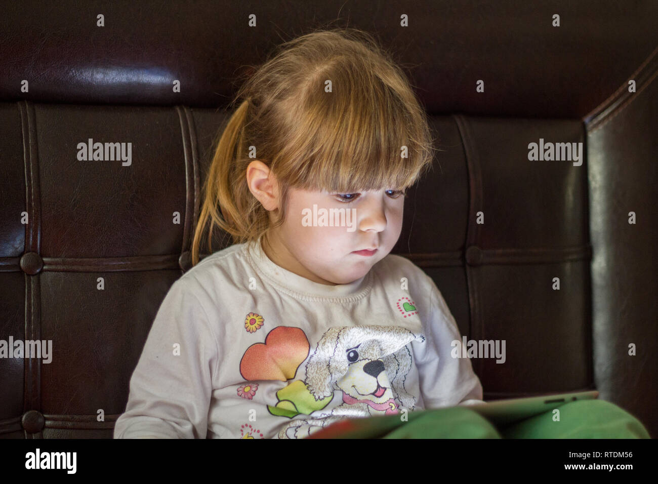 Kleines Mädchen Kind spielt mit tablet pc und schaut Stockfoto