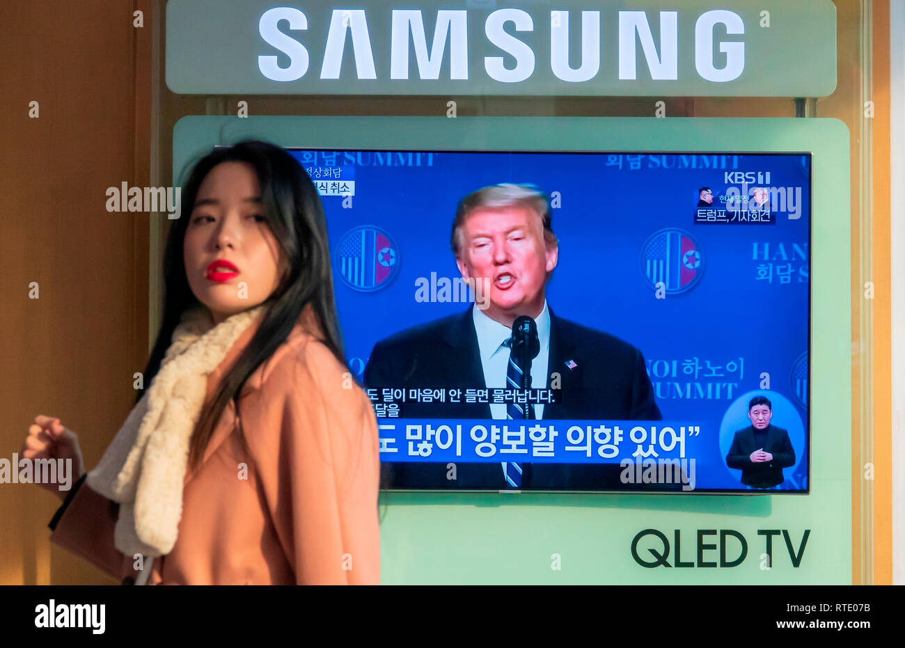 Gipfeltreffen zwischen Nordkorea und den USA, Feb 28, 2019: Pressekonferenz von US-Präsident Donald Trump, der ein Gipfel mit dem nordkoreanischen Führer Kim Jong-Un in Hanoi, Vietnam, ist live auf einem lokalen TV-Netzwerk als Frau Vergangenheit Spaziergänge am Bahnhof Seoul in Seoul, Südkorea. Der zweite Gipfel zwischen Trumpf und Kim am Donnerstag geschlossen mit No Deal als Kim's Angebot der denuklearisierung Schritte im Gegenzug für Sanktionen relief unterzeichnet unter den Erwartungen der Trumpf, den lokalen Medien berichtet. Quelle: Lee Jae-Won/LBA/Alamy leben Nachrichten Stockfoto