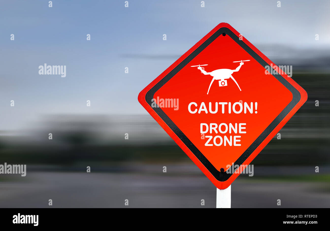 Warnschild für Drohnenflugbetrieb. Rotes Warnschild mit verschwommenem Hintergrund. Symbol für die Drohnenüberwachung. Stockfoto