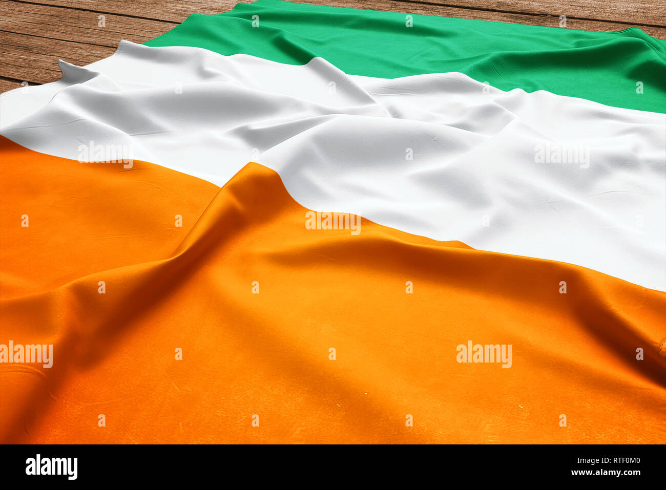 Flagge von Cote d'Ivoire, die auf einem hölzernen Schreibtisch Hintergrund. Seide in Côte d'Ivoire Fahne Ansicht von oben. Stockfoto