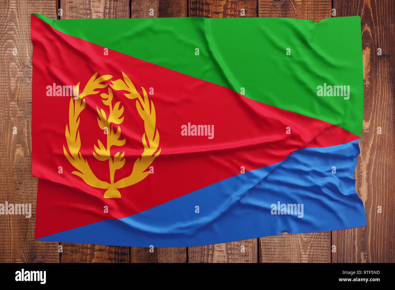 Flagge Eritrea auf einem Holztisch Hintergrund. Faltige eritreischen Flag Startseite anzeigen. Stockfoto