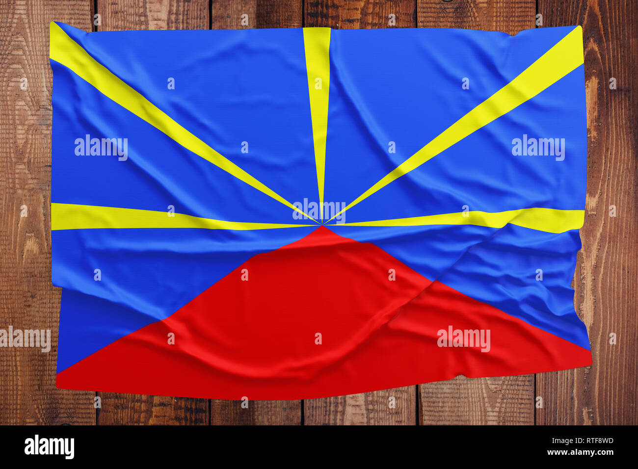 Flagge von Reunion auf einem Holztisch Hintergrund. Faltige Flag Startseite anzeigen. Stockfoto