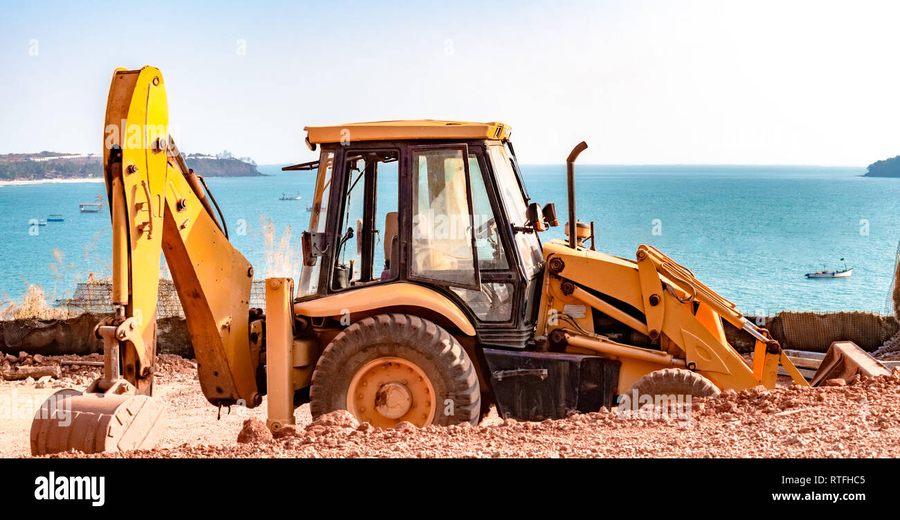 Schönes Foto von JCB-Maschine auf einer Baustelle für Erde Aushub verwendet. Ruhige blaue Meer und klaren Himmel ist das Hinzufügen von Charme, der auf das Foto. Stockfoto