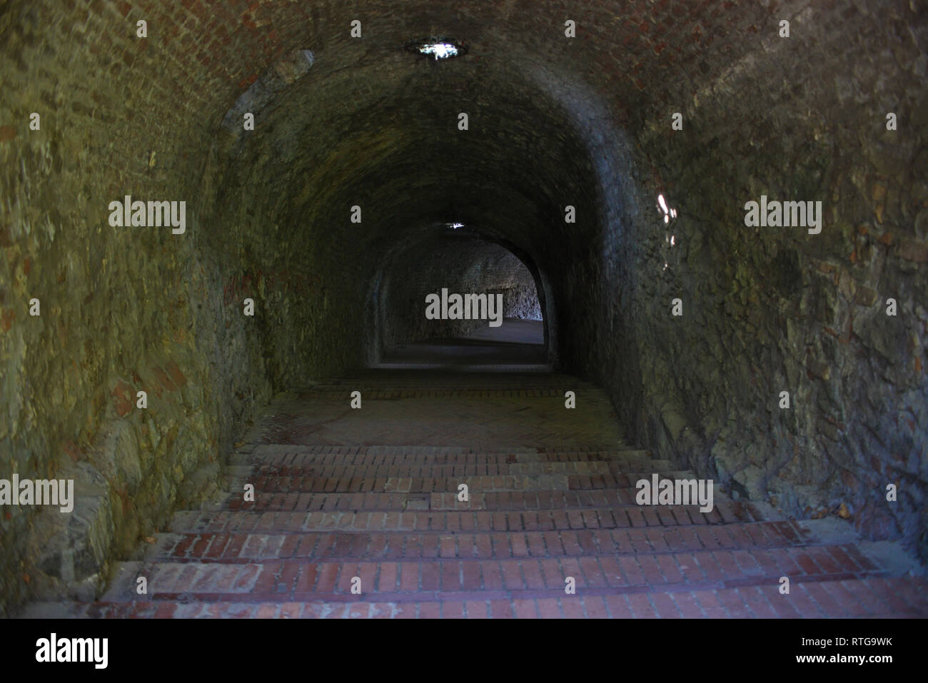 Langen, dunklen Tunnel mit Treppe hinunter Stockfoto