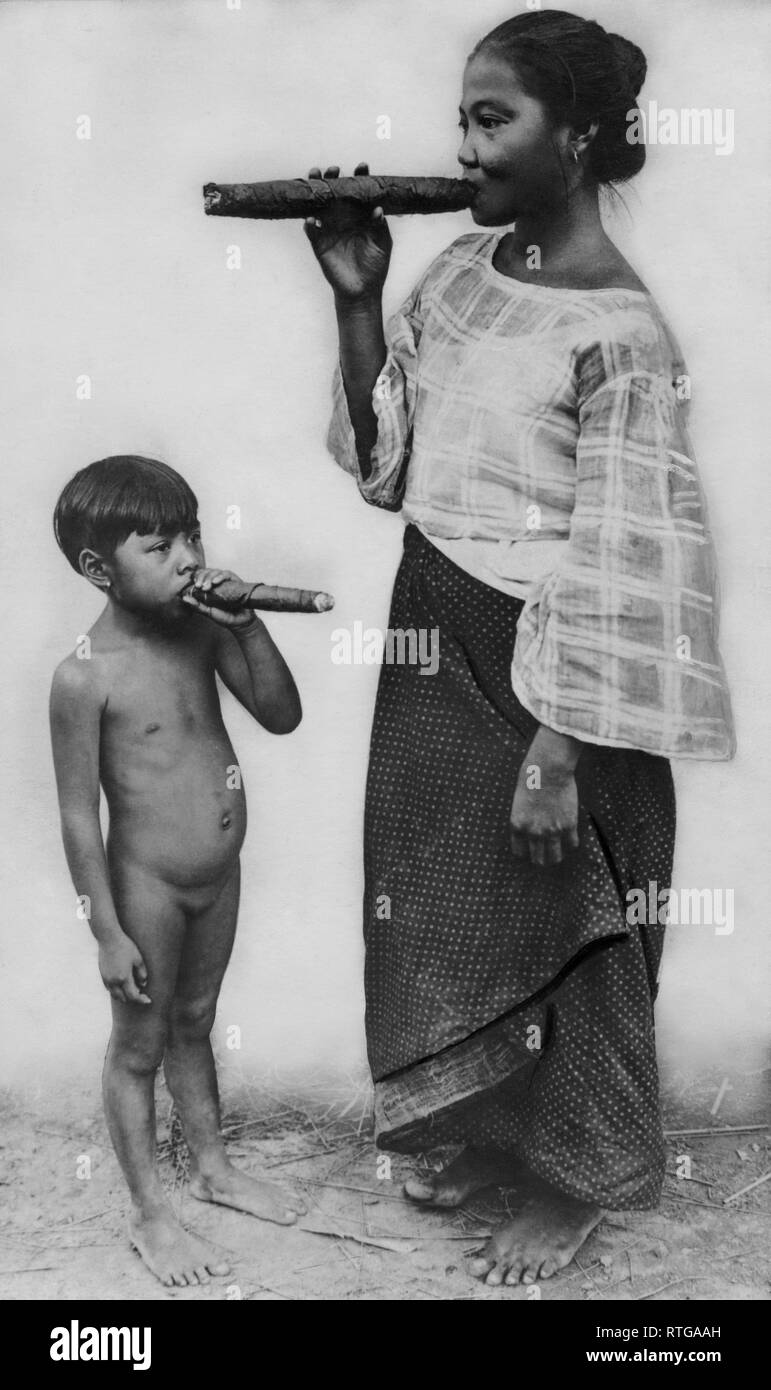 Asien, Philippinen, Frau mit Tochter, mit riesigen Zigarren Posing, 1932 Stockfoto