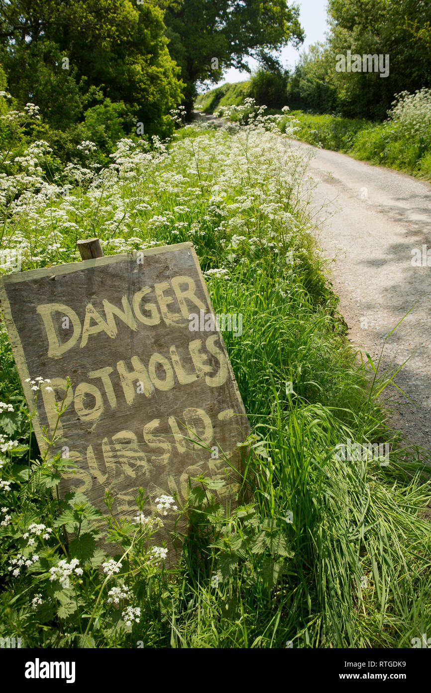 Ein Schild an der Seite eines ländlichen Lane Warnung der Schlaglöcher und Bodensenkungen. Dorset England UK GB Stockfoto