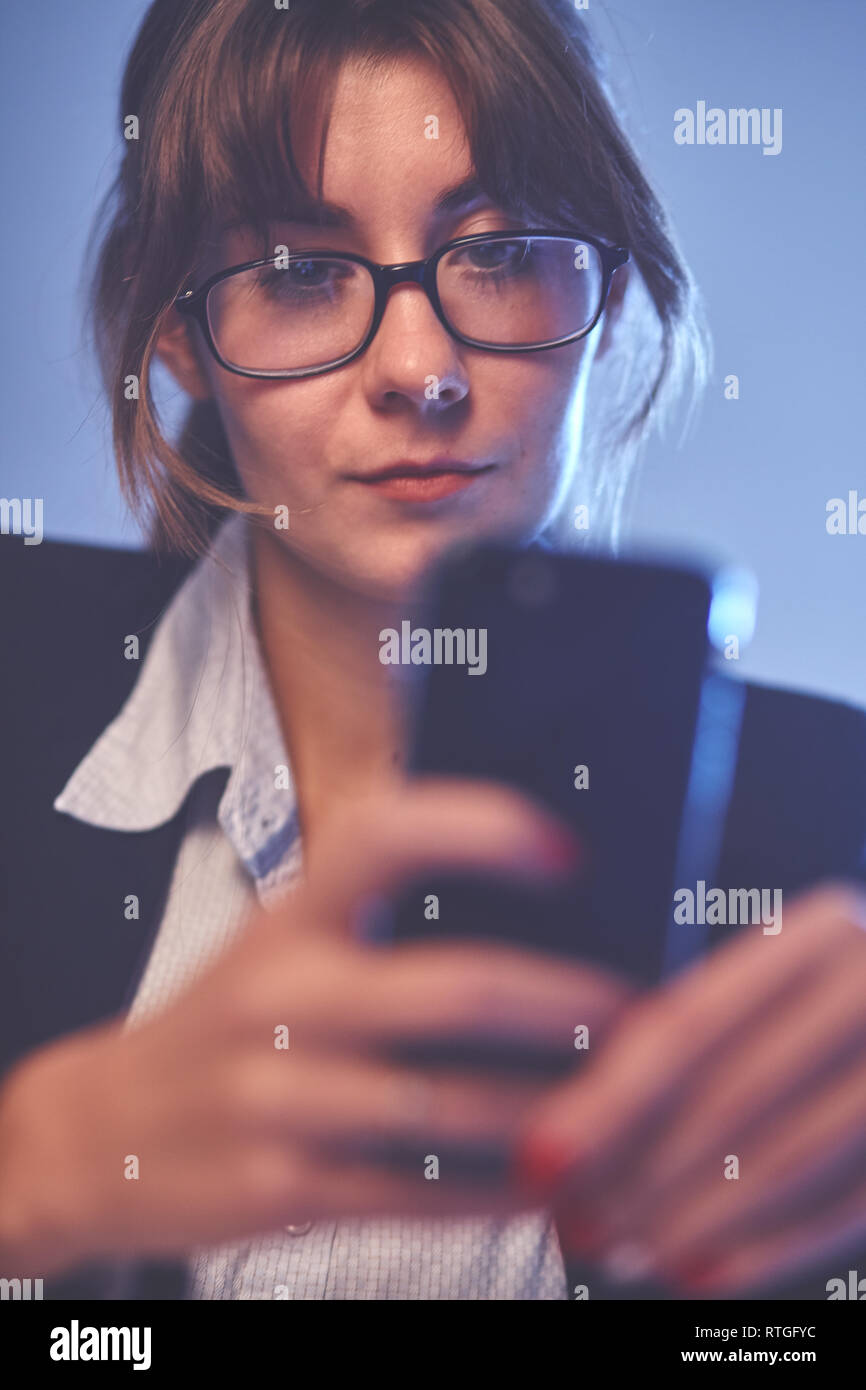 Portrait von betonte Büro junge Frau mit Handy in die Hände am Bildschirm mit Cross Face Ausdruck suchen, wütend an stressigen Texte und Anrufe Stockfoto
