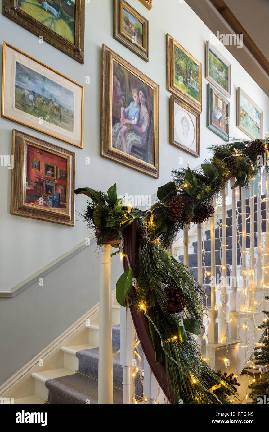 Gerahmte Kunstwerke von Elizabeth Parsons im Treppenhaus mit Girlanden und Lichtern Stockfoto