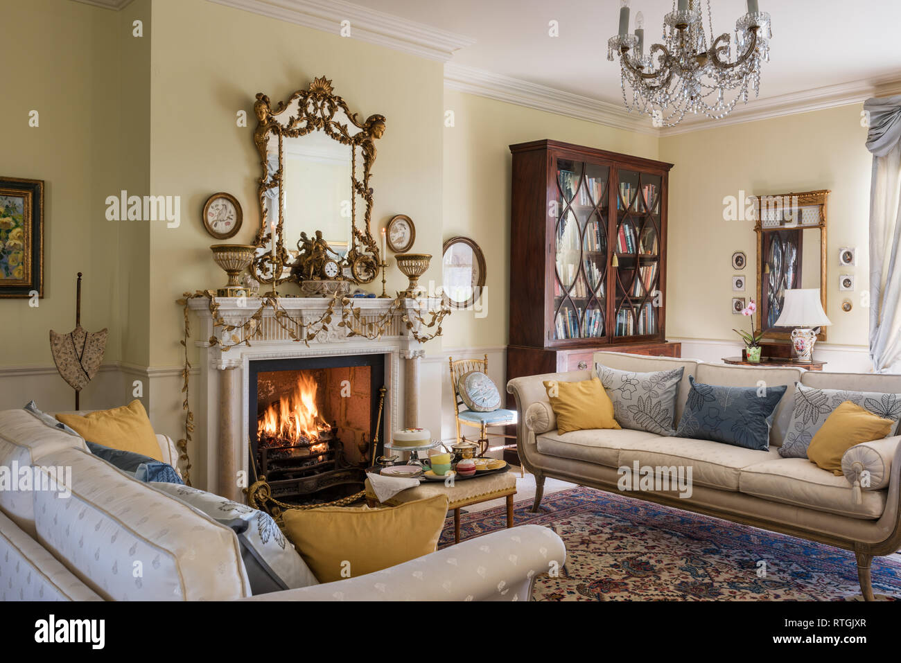 Orientteppich mit Regency Stil Sofas und Blattgold Girlande auf englischen Kamin Stockfoto