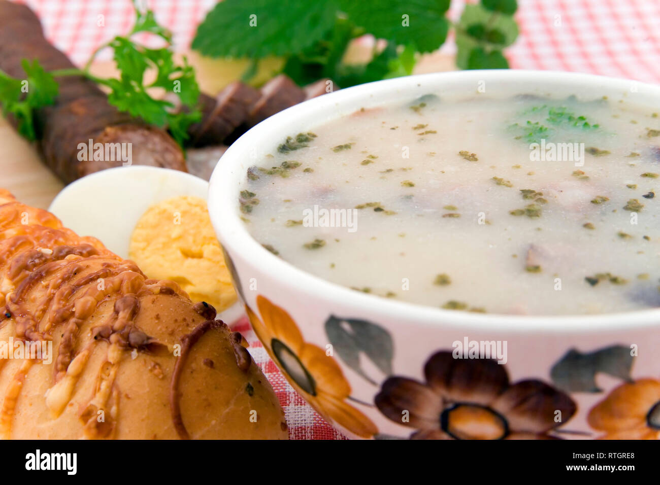 Saure Suppe mit Ei, Wurst und Brot - traditionelle polnische Mahlzeit Stockfoto