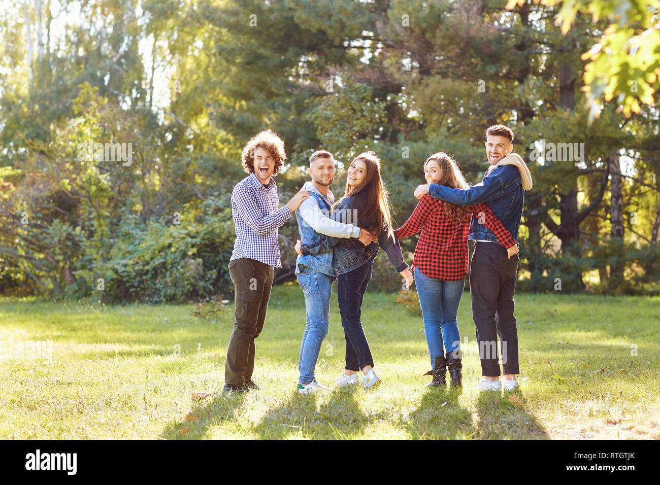 Junge Leute zum Lachen beim Stehen in einem Park im Frühling. Stockfoto