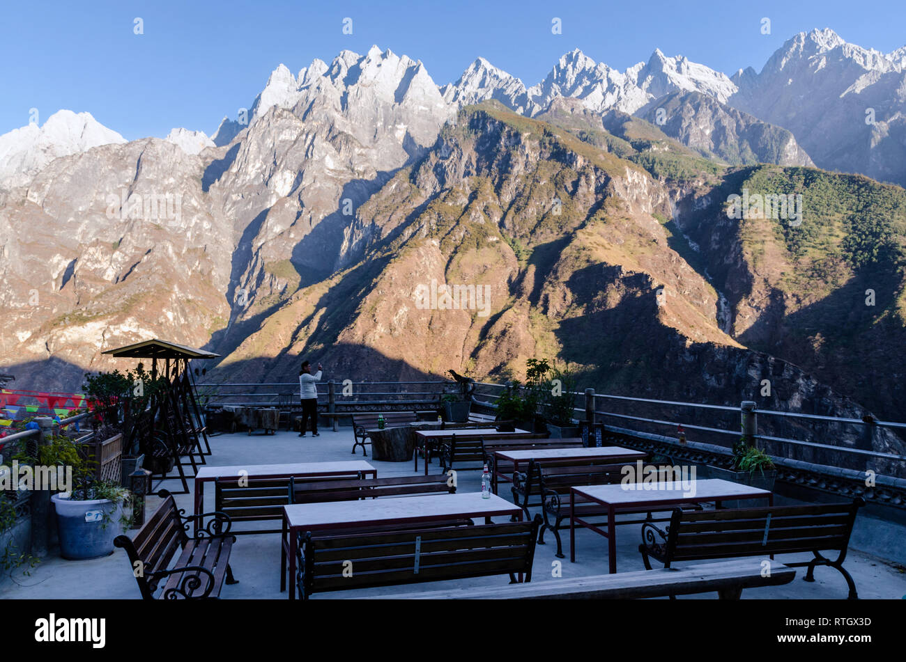 Touristen, die Bilder von den Bergen aus Der Kaffee Pferd pension Terrasse, Tiger Leaping Gorge, Yunnan Stockfoto