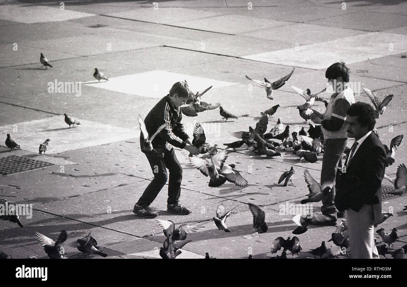 1970, Trafalgar Square, Cental London, England, Großbritannien, Zwei kleine Jungen, die mit den Tauben spielen. Obwohl „wilde Vögel“, sind Tauben in der Regel unter den Menschen entspannt und waren zu dieser Zeit eine große Touristenattraktion auf dem Platz, da das Füttern erlaubt war. Stockfoto
