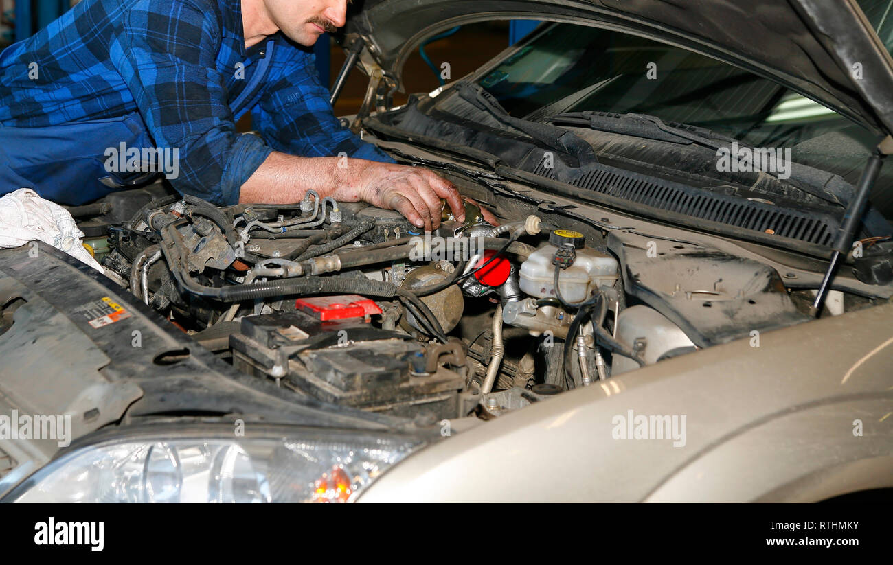 Mechaniker arbeiten mit Motor im Auto Service Stockfoto