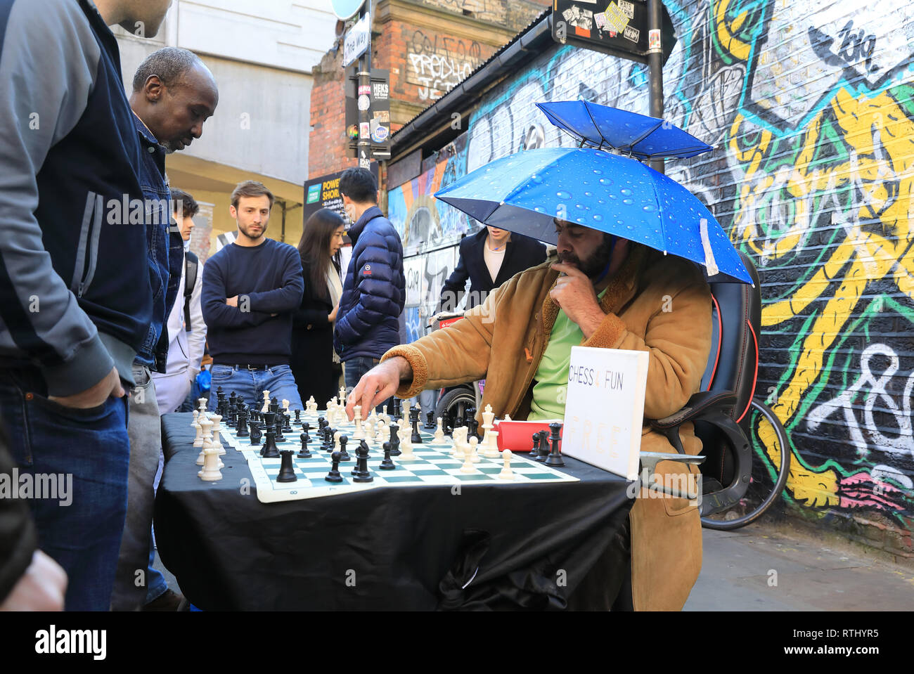Schachspieler anspruchsvolle Touristen auf lebendige Sonntag Brick Lane Markt in Bethnal Green in East London, UK Stockfoto