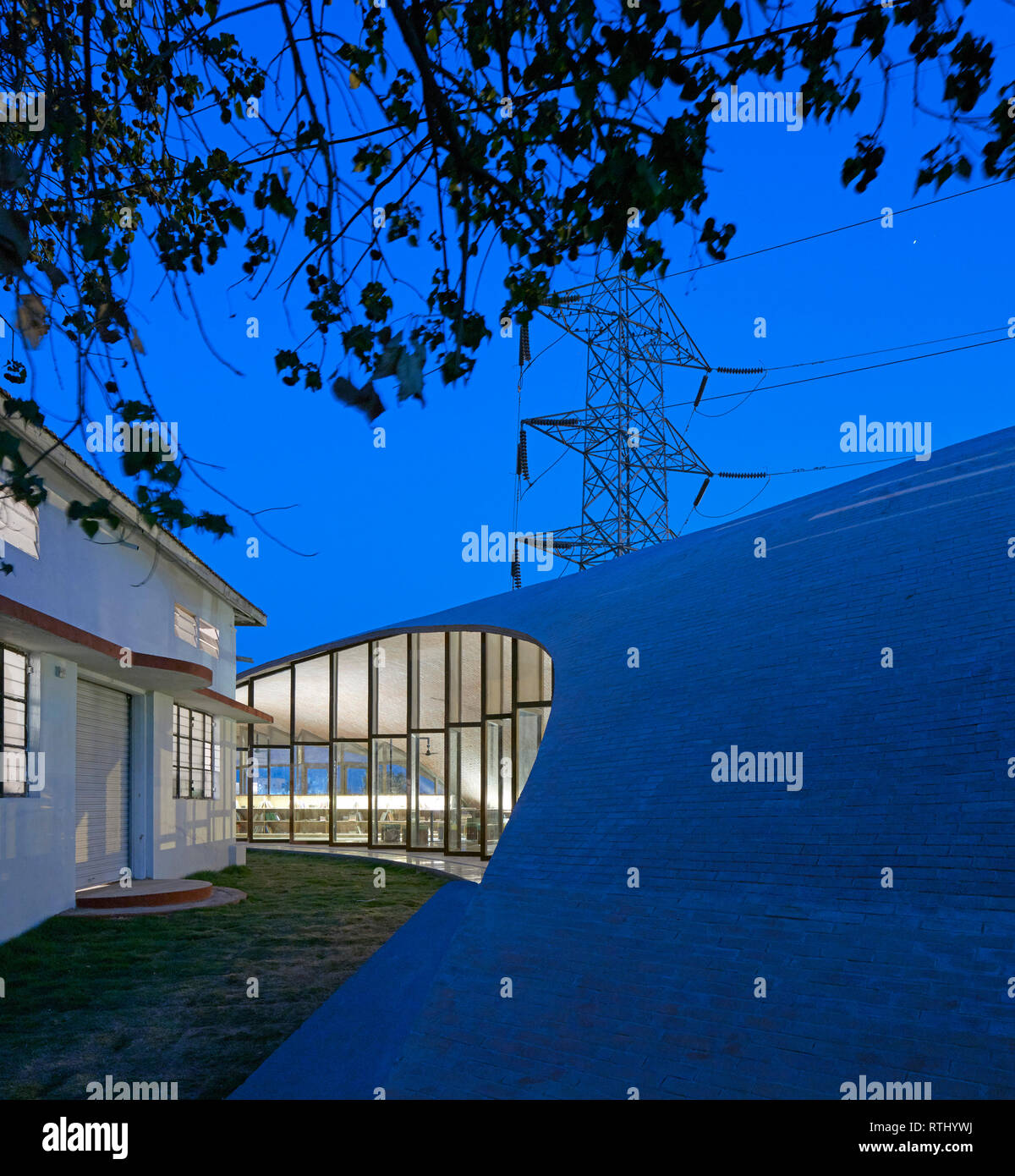 Seitenansicht in der Abenddämmerung. Maya Somaiya Bibliothek, Kopargaon/Maharashtra, Indien. Architekt: Sameep Padora und Associates (SP+A), 2018. Stockfoto