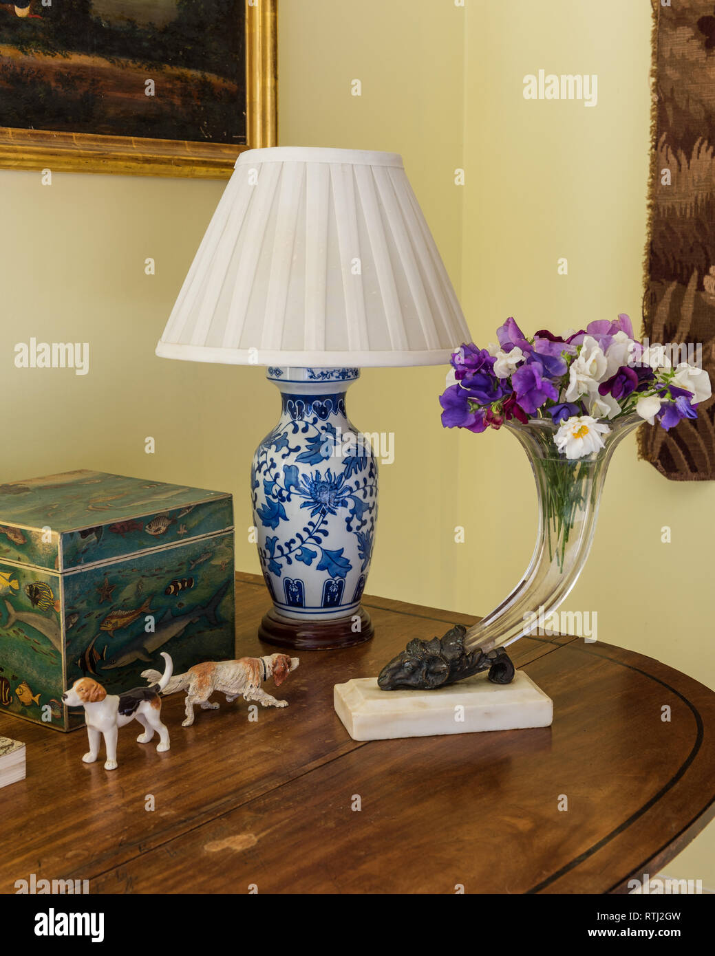 Schnittblumen in Glasvase mit Lampe und Ornamente Stockfoto