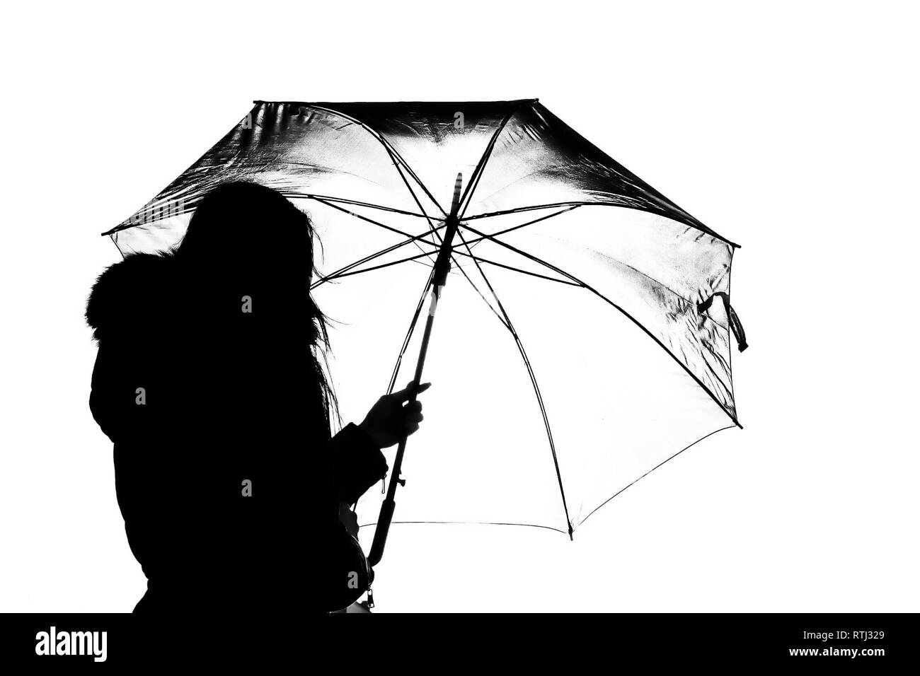 Schöne Hintergrundbeleuchtung mit Modell unter einem offenen Regenschirm in Silhouette Stockfoto