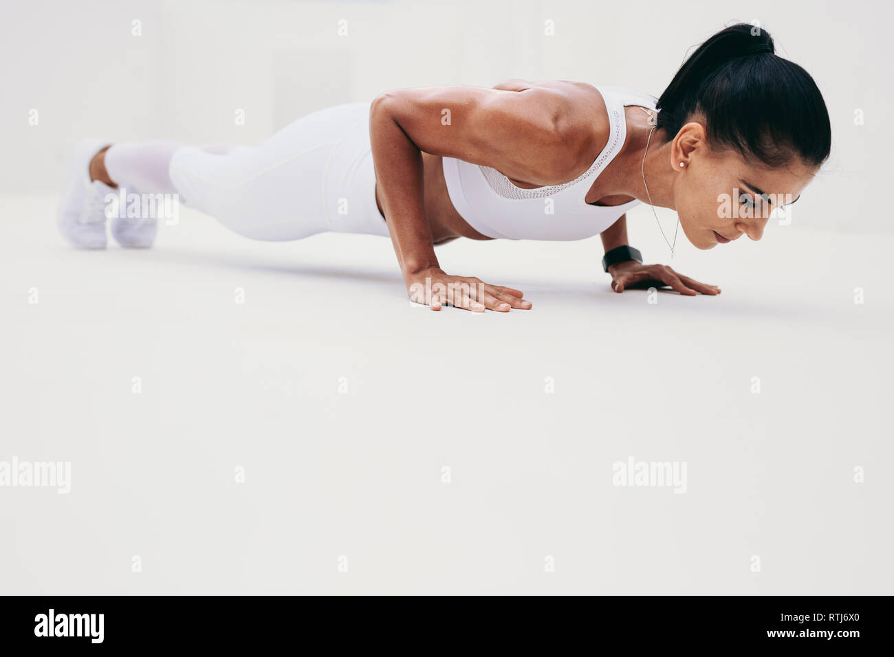 Seitenansicht eines Fitness Frau tun Push-ups. Frau in Fitness Kleidung tun Fitness Training. Stockfoto
