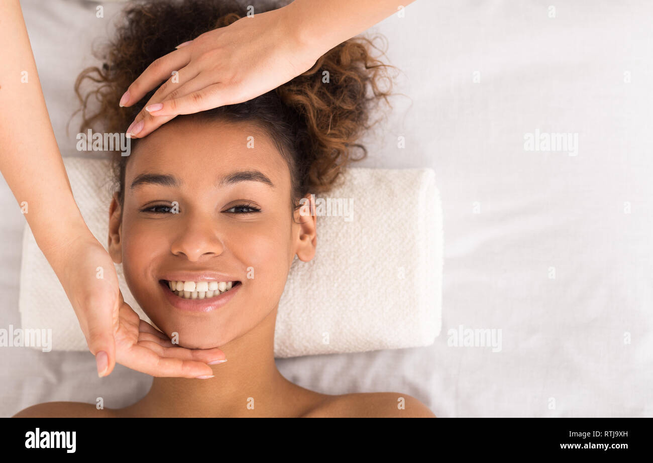 Afrikanisch-amerikanische Frau genießen Gesicht Massage im Schönheitssalon Stockfoto
