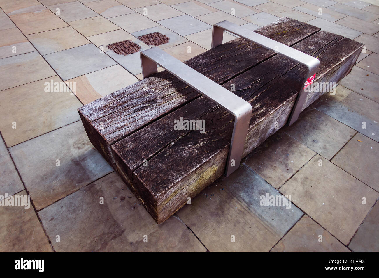 Zeitgenössische Holzblock und Stahl Sitzbank neben dem Regents Canal in der Nähe von Kohle Tropfen Yard, Kings Cross, London Stockfoto