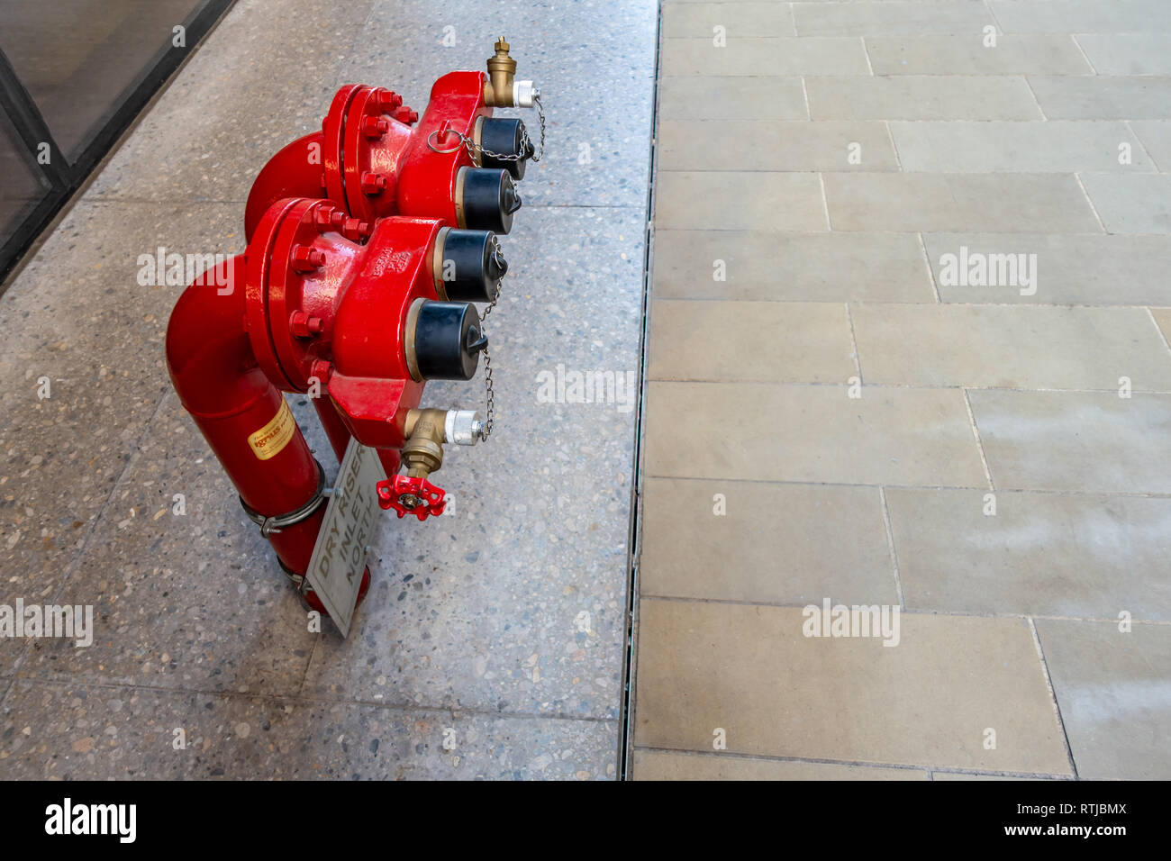 2 modernen roten Hydranten und trockene Steigleitung außerhalb der Universal Music UK Hauptquartier in vier Pancras Square, Kings Cross, London Stockfoto