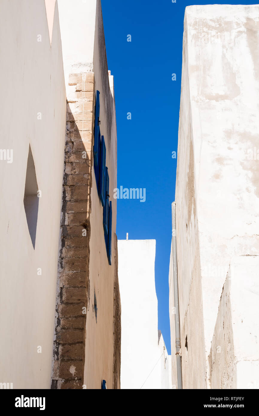 Detail der weißen Wände der Häuser entlang der Straße. Blaue Fensterläden, passenden Farbe mit den strahlend blauen Himmel. Essaouira, Marokko. Stockfoto
