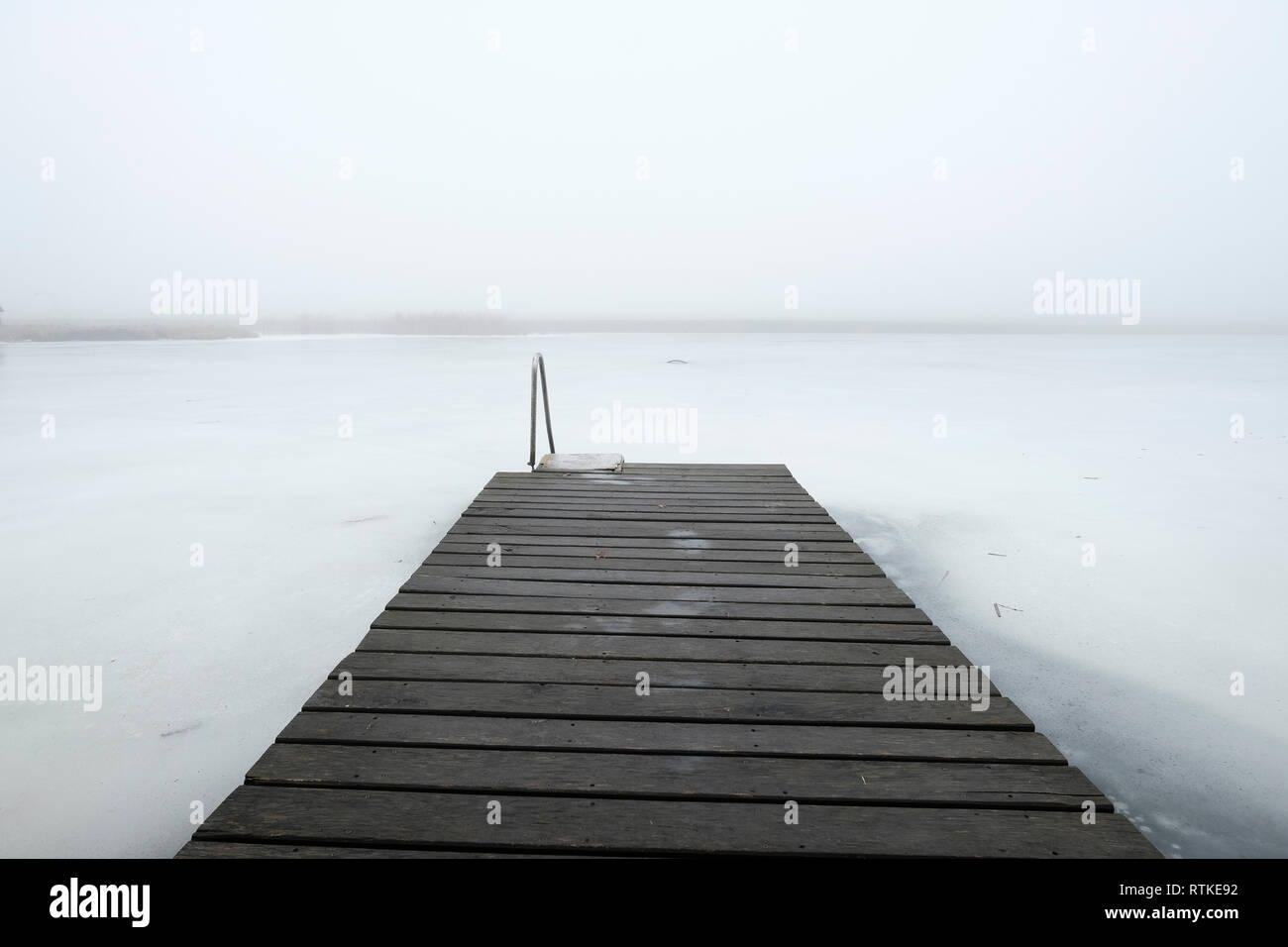 Hölzerne Pier in einem gefrorenen Wasserreservoir in Zelva Bezirk Grodno Region. Weißrussland Stockfoto