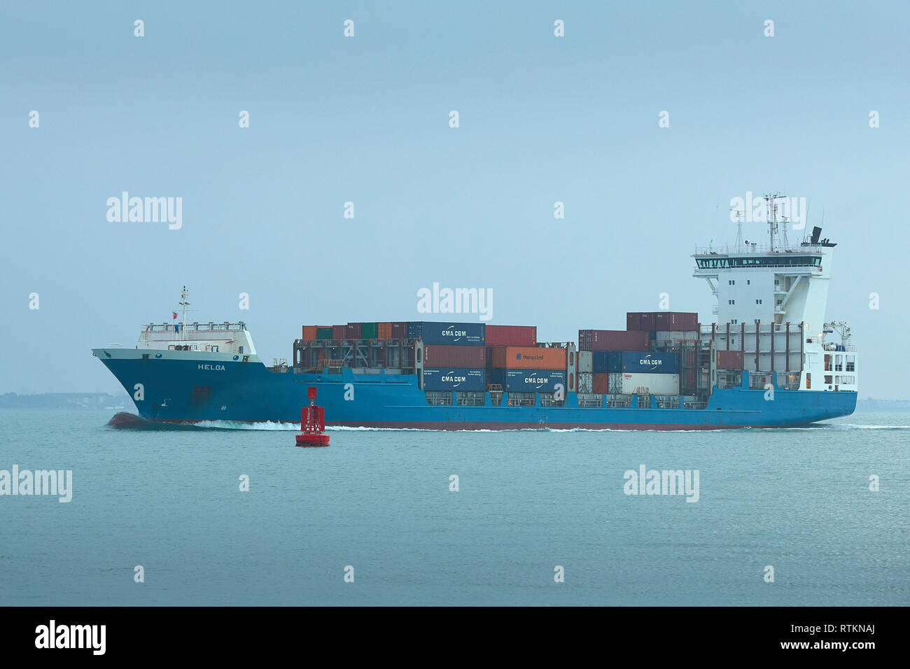 Der kleine General Cargo Ship, Helga, beladen mit Container, Ansätze der Hafen von Southampton, Hampshire, Großbritannien. Stockfoto