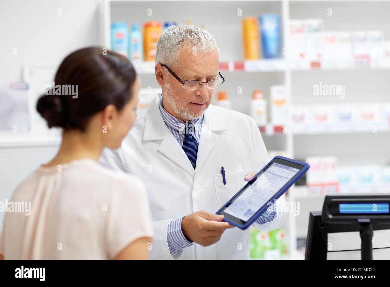 Apotheke und Kunden mit Tablet-PC in der Apotheke Stockfoto Apotheke und Kunden mit Tablet-PC in der Apotheke Stockfoto