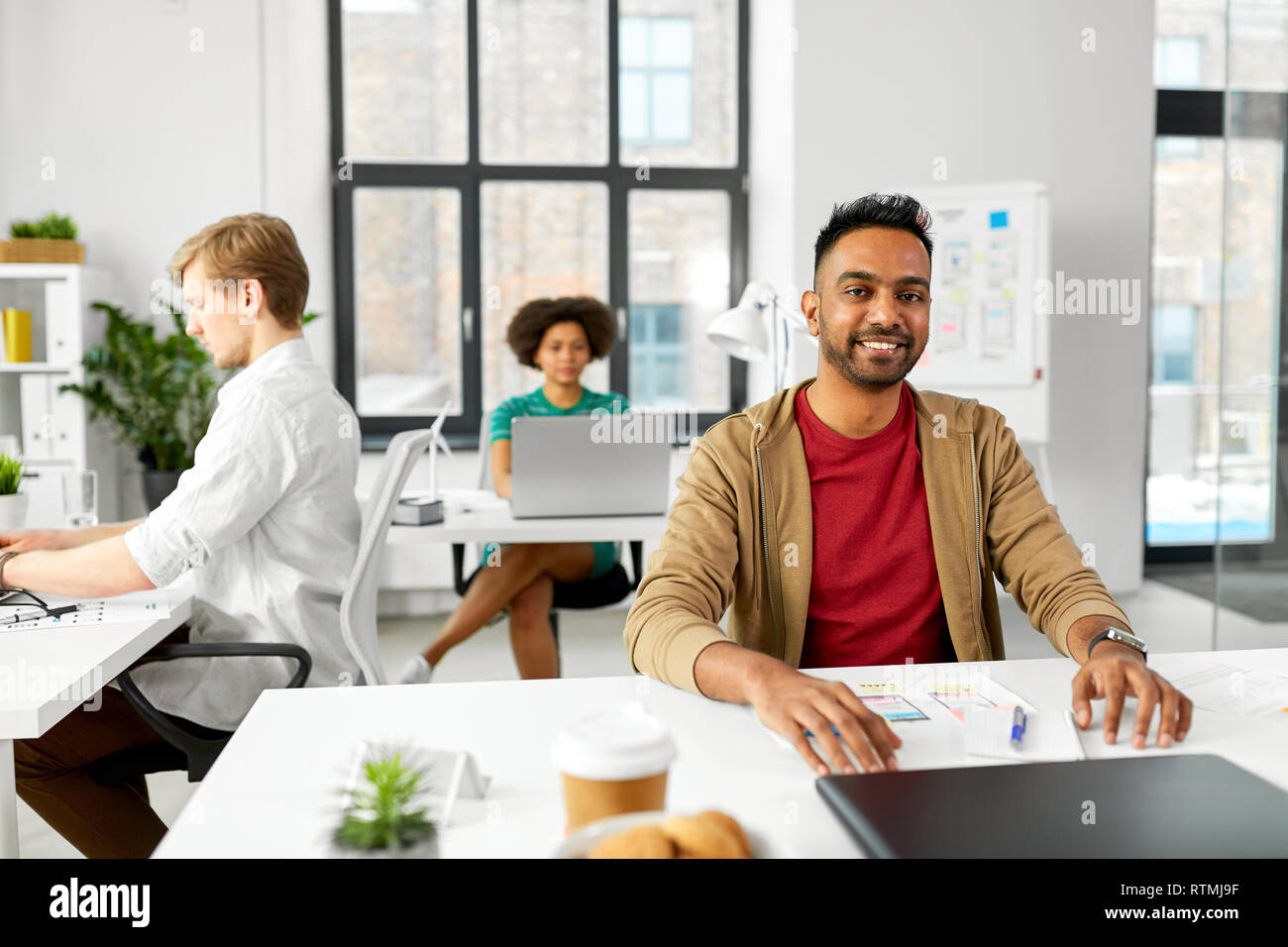 Indische männlichen kreative Mitarbeiter mit Laptop im Büro Stockfoto