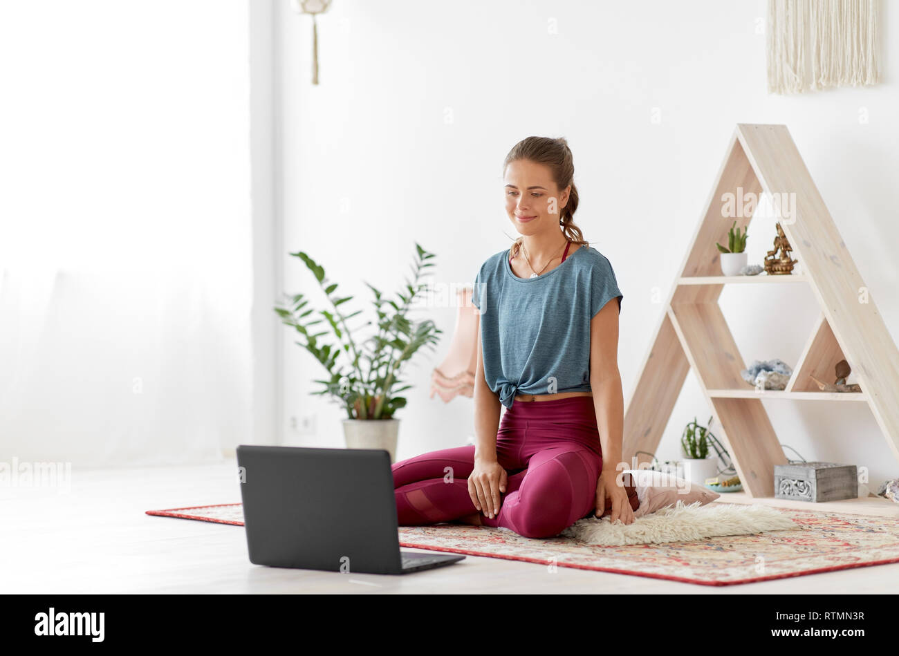 Frau mit Laptop bei Yoga Studio Stockfoto
