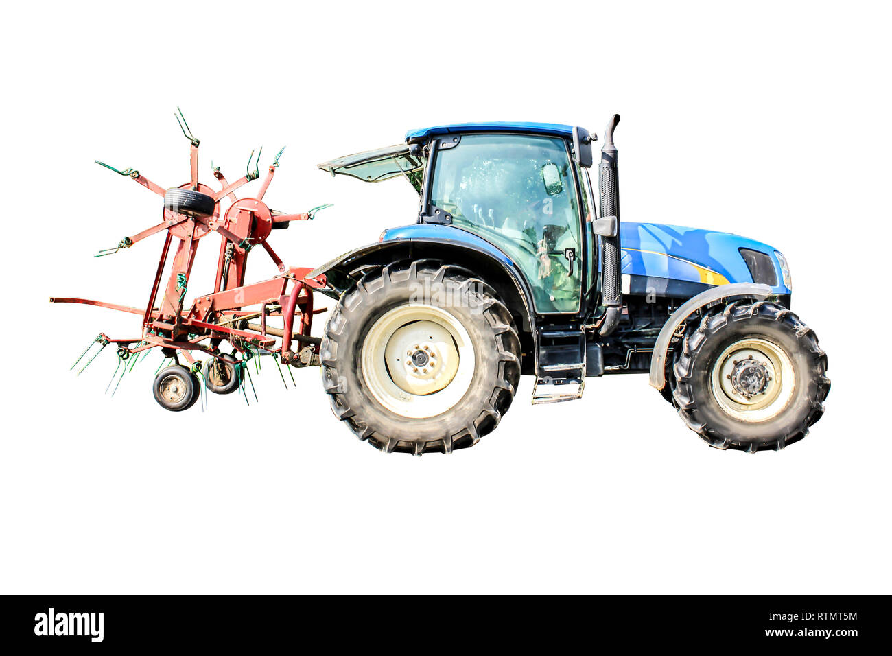 Leistungsstarke Traktor mit einem großen Gras heuwender. Isoliert Foto. Notwendige Ausrüstung für eine Molkerei. Stockfoto