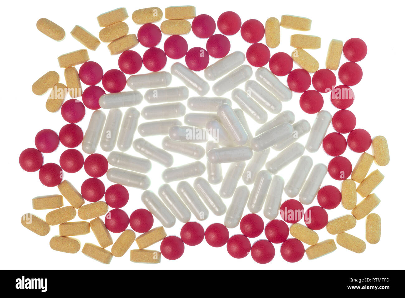 Horizontale Schuß von roten, weißen und gelben Pillen, Tabletten und Kapseln in einem kreisförmigen Muster isoliert auf Weiss. Stockfoto