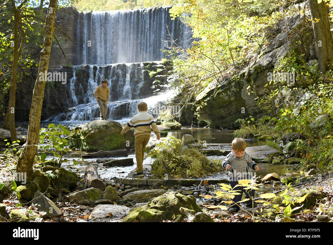 Drei Jungen spielen in einem Wasserfall und in der Nähe Creek Stockfoto
