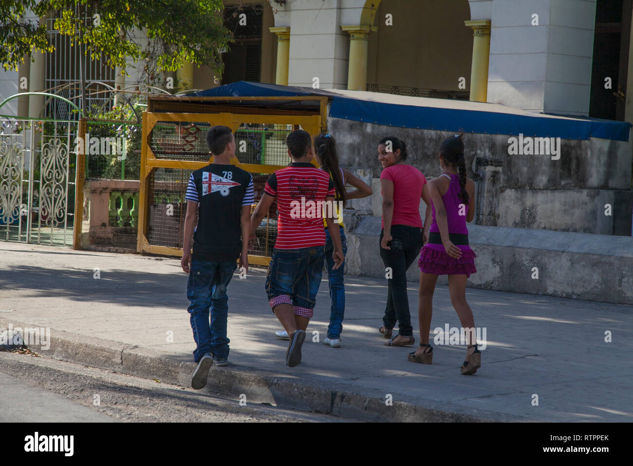 Havanna, Kuba - 12. Januar 2013: Ein Blick auf die Straßen der Stadt mit dem kubanischen Volk. Jugendliche gehen lachend auf der anderen Straßenseite. Stockfoto