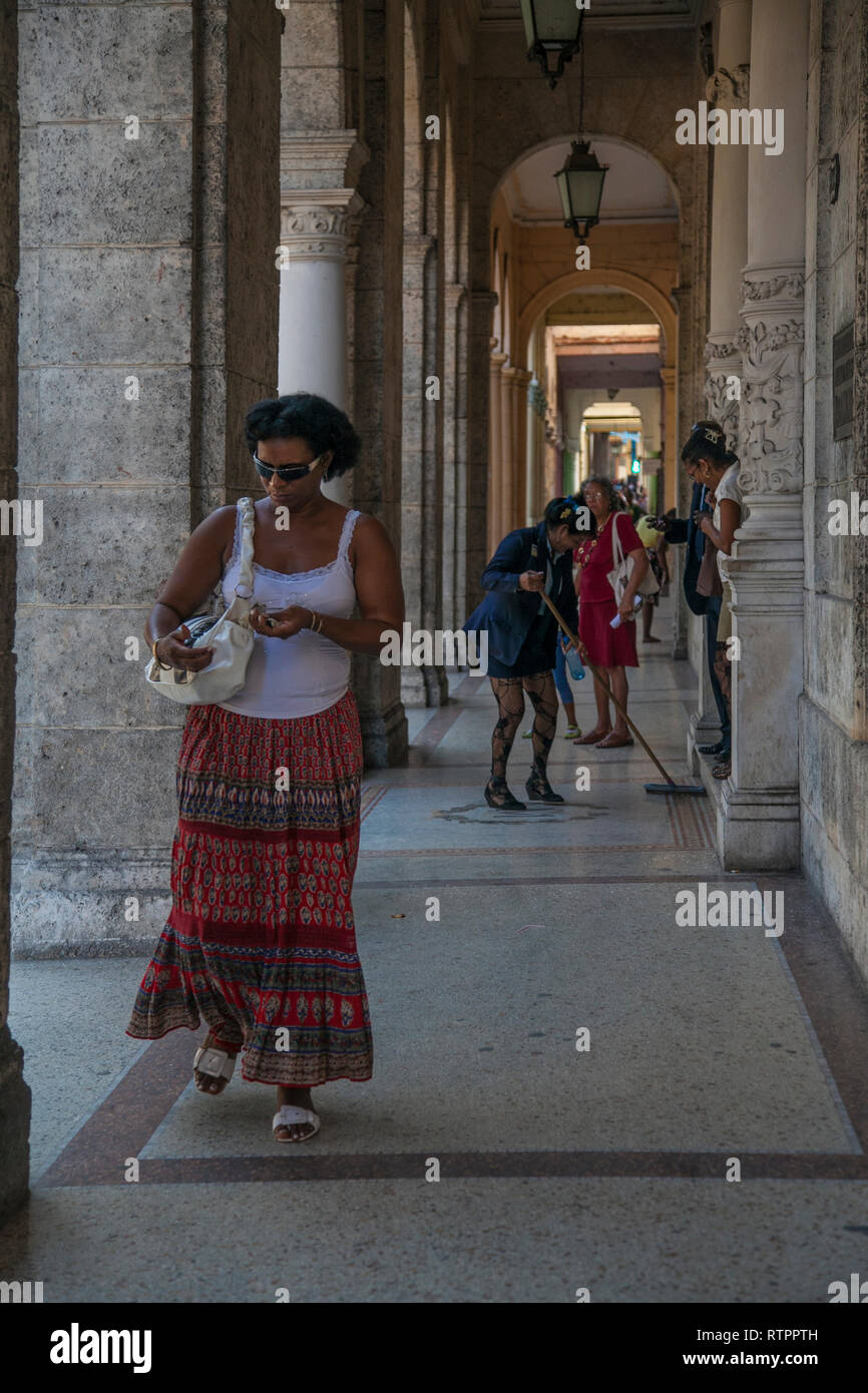 Havanna, Kuba - 20 Januar 2013: Ein Blick auf die Straßen der Stadt mit dem kubanischen Volk. Eine Frau geht durch die Arkaden. Stockfoto