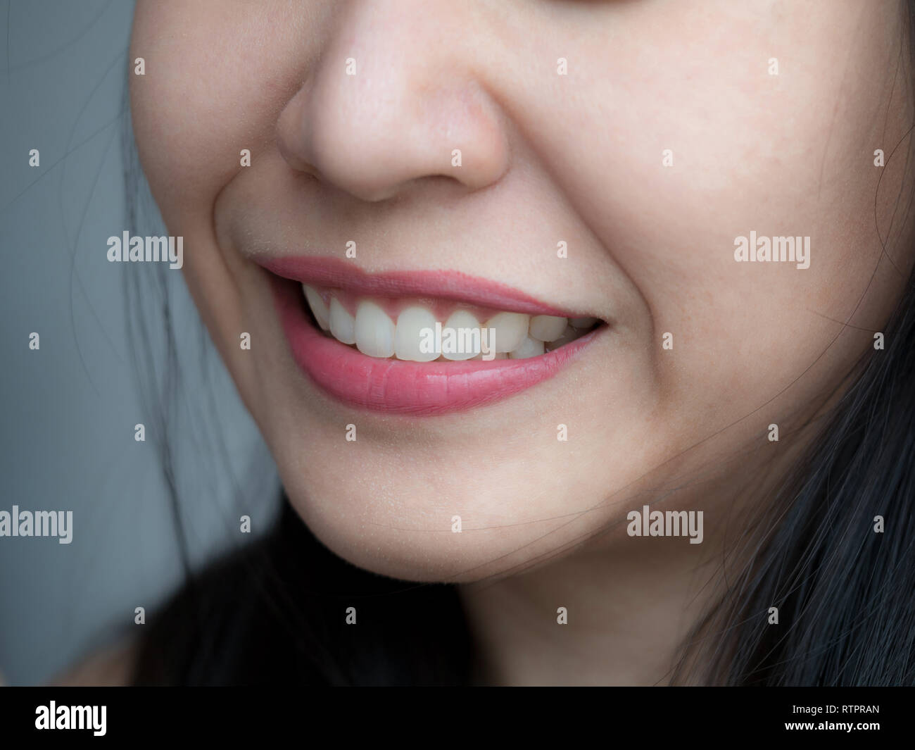 Closeup Schuß von Asiatische chinesische Thai Frau weibliche Make-up Gesicht. Frau mit roten Lippen Lippenstift und gesunden zahnmedizinischen Weiß große perfekte Zähne. Zahnmedizinische Stockfoto