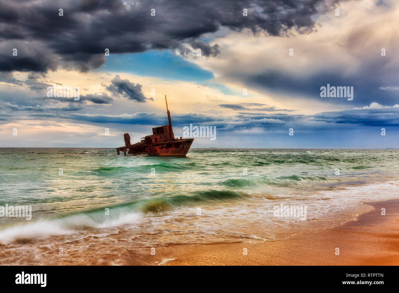 Alten rostigen Schiffswrack von Sygna Cargo Container schiff am Stockton Beach von Australien bei stürmischem Wetter langsam in salzigen Wasser des Pazifischen Ozeans zu sterben. Stockfoto