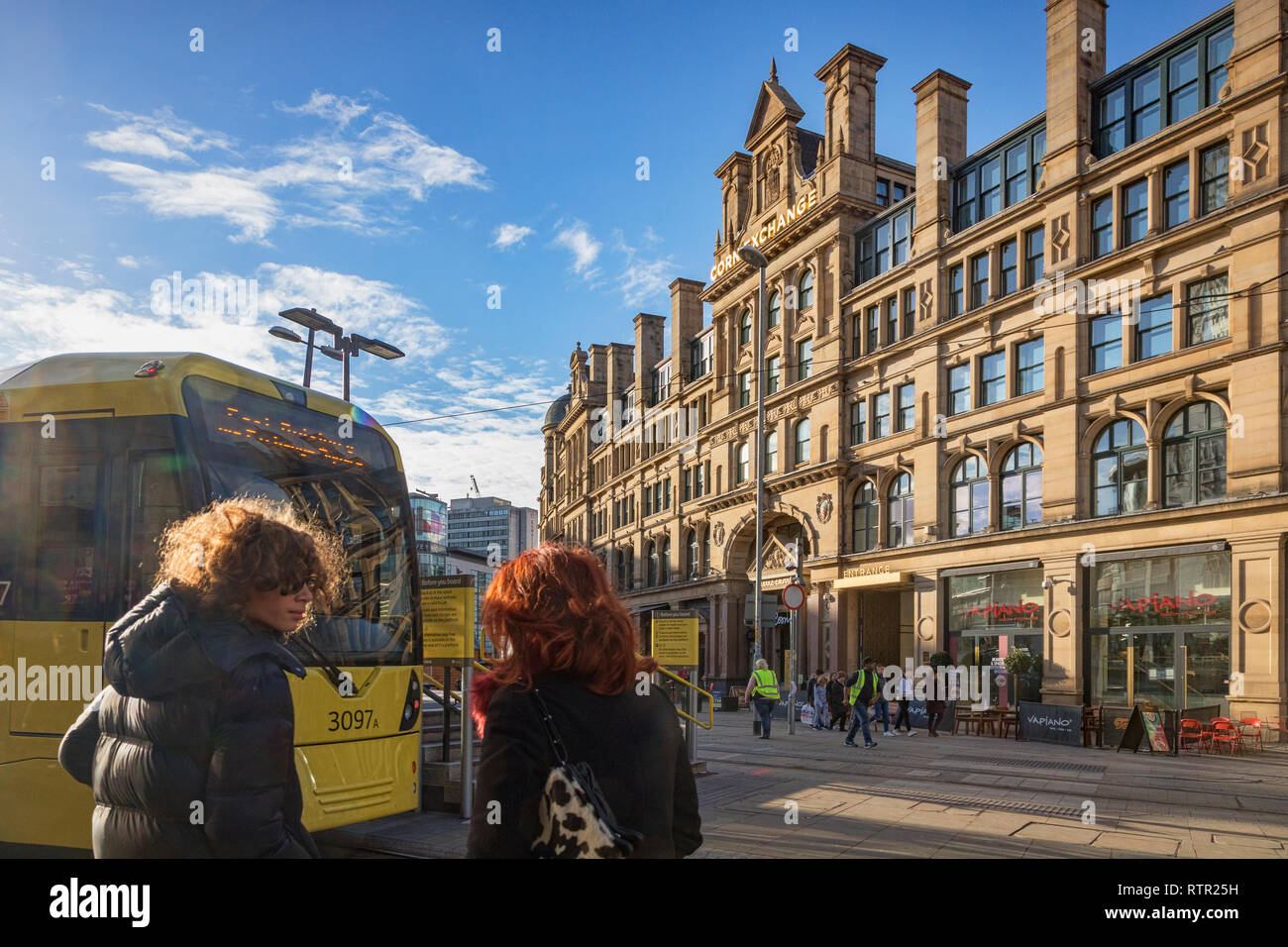 2. September 2018: Manchester, UK-Exchange Square, mit Corn Exchange Gebäude, Metrolink Tram, zwei junge Frauen mit Hintergrundbeleuchtung, Haar, und der Spiegelungen an. Stockfoto