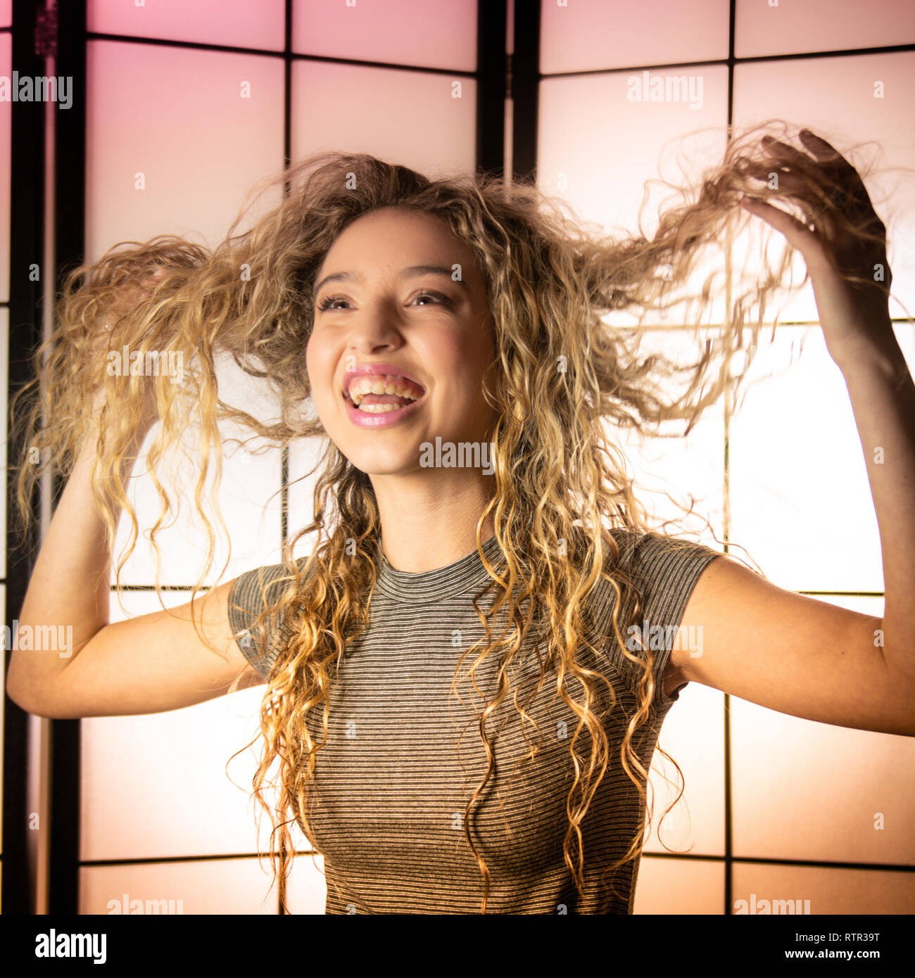 Ein junges Mädchen ist ihre Haare mit Unterhaltung. Stockfoto