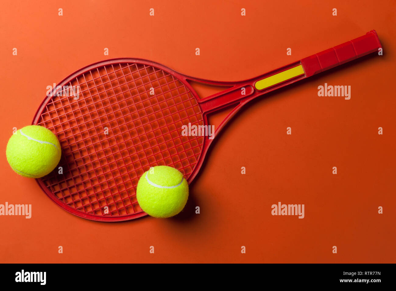 Tennis Schläger und Ball auf rotem Hintergrund Stockfoto