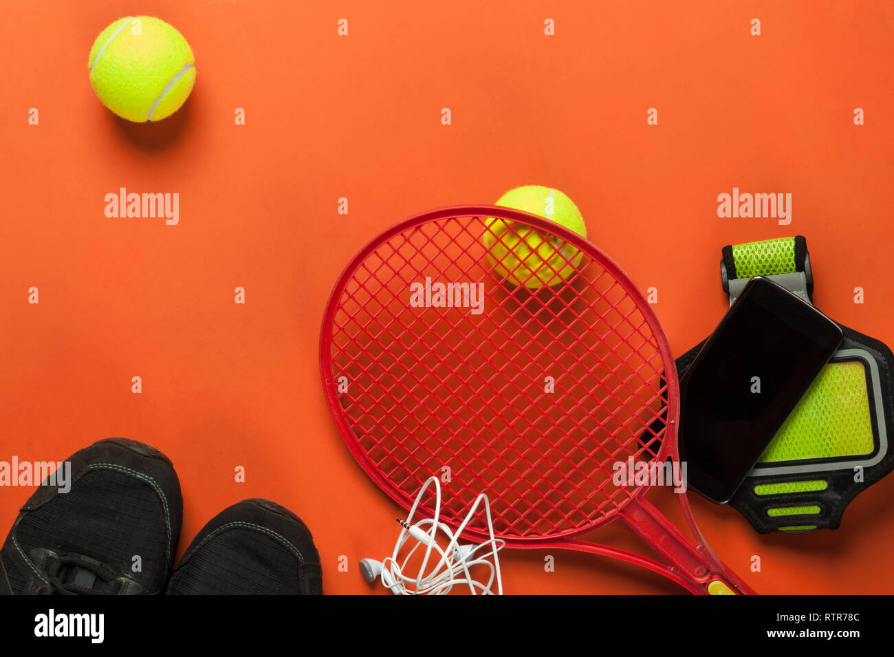 Tennis mit Tennisschläger und Smartphone auf rotem Hintergrund einstellen Stockfoto