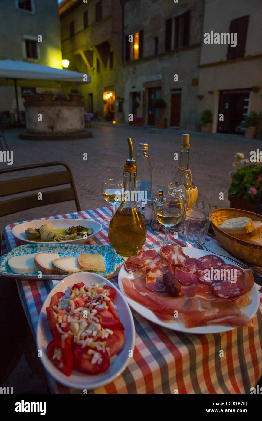 Weißwein und leckere italienische hausgemachte Snacks. Italienisches Essen mit hausgemachten Antipasti, Käse und Schinken, Pienza, Toskana, Italien Stockfoto