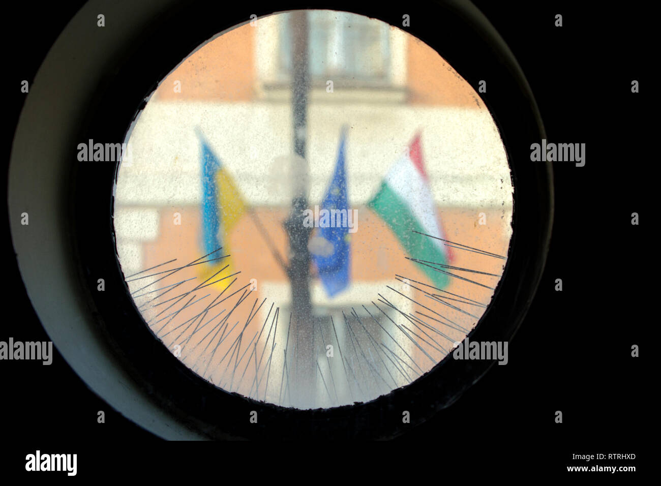 Die ungarische und die Europäische Union Flaggen von Dornen als aus der Runde einer Kirche Fenster sehen verschwommen Glas umgeben. Stockfoto
