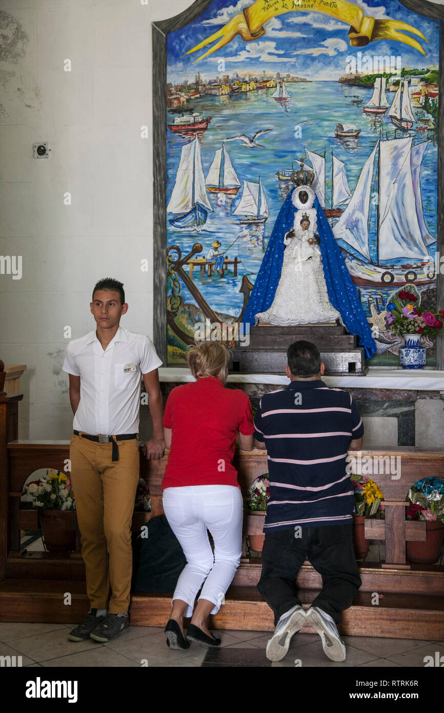 Havanna, Kuba - 12 Januar 2013: Blick auf die Altstadt von Plätzen und Straßen. Zwei erwachsene Beten eine schwarze Madonna. Ihr Sohn ist durch die Art und Weise. Stockfoto