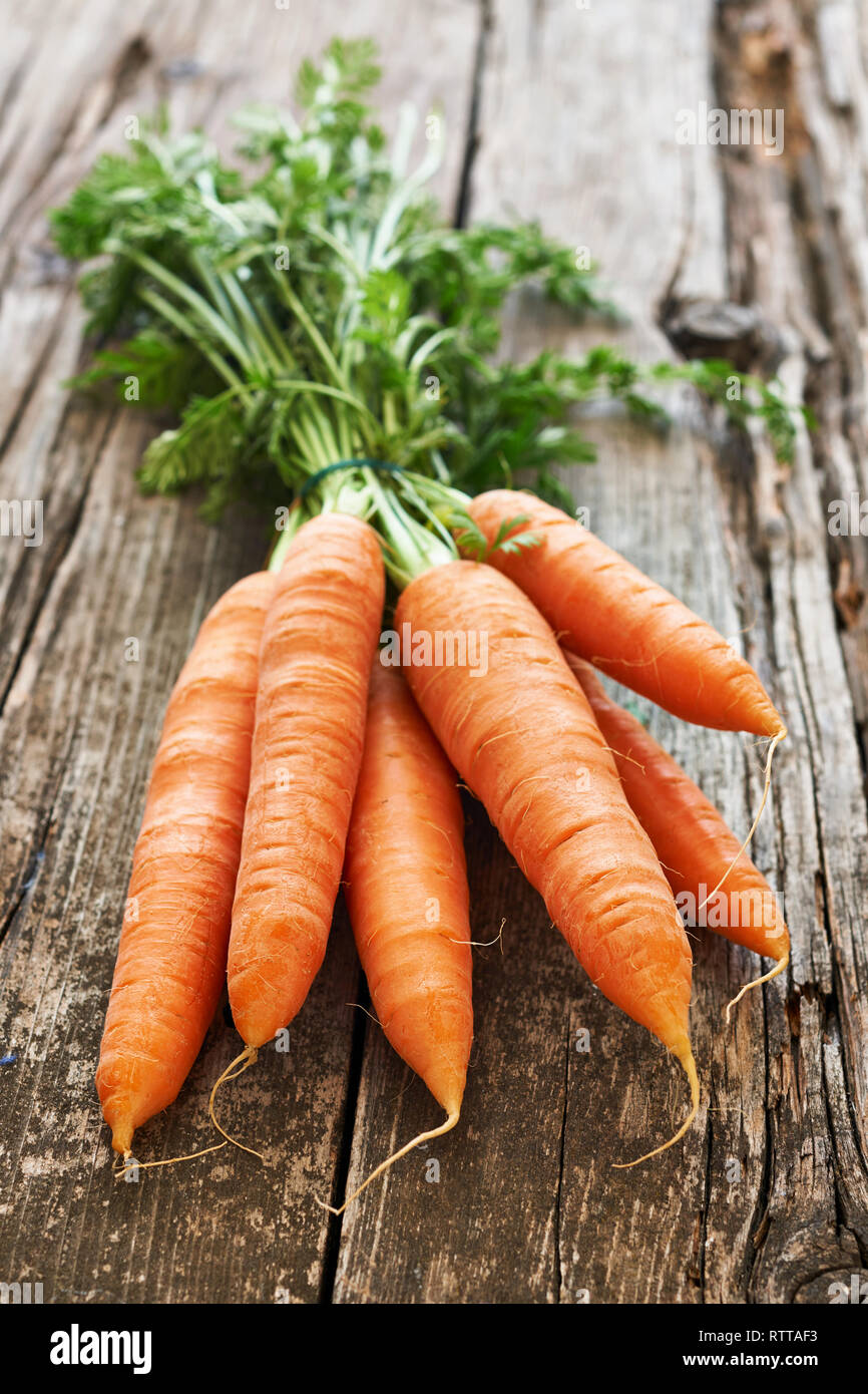 Frisch und leckere Orange Karotten erstreckt sich auf einem alten Holztisch Stockfoto