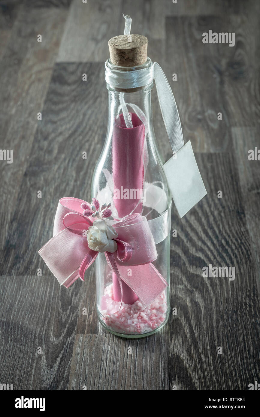 Eine Flasche mit einer Nachricht auf der Innenseite mit Salbe und Blume dekoriert Stockfoto