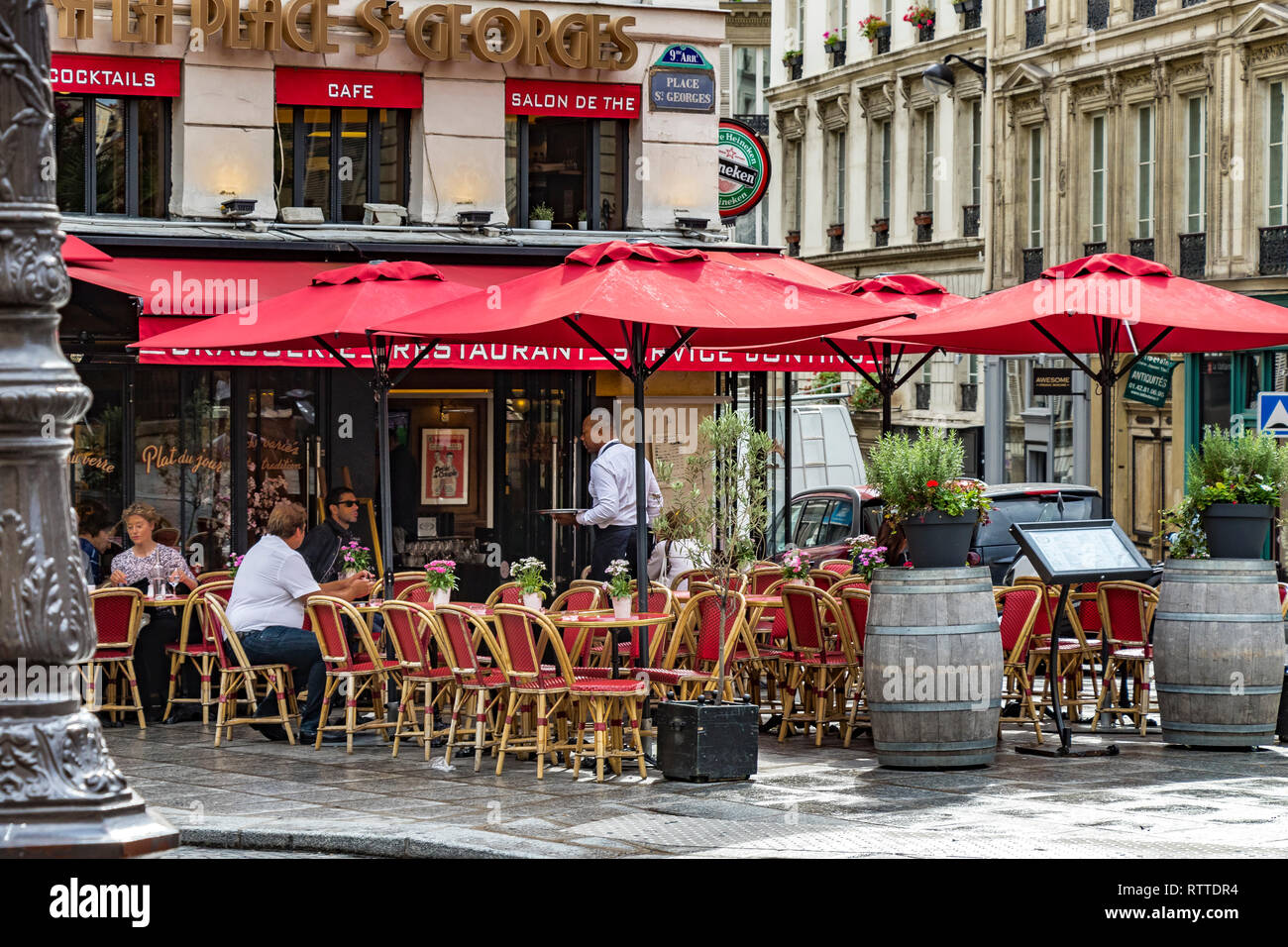 Personen, die an Tischen vor DEM à la Place Saint-Georges sitzen, einem Café-Restaurant in St. Georges, im 9. Arrondissement von Paris, Frankreich Stockfoto