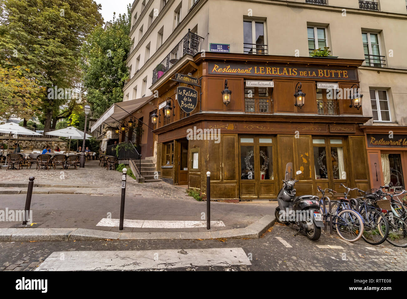 Fahrräder und Motorroller außerhalb Restaurant Le Relais De La Butte Montmartre, Paris geparkt Stockfoto